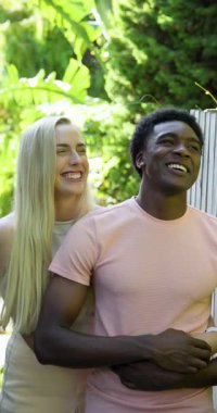 Dikey video: Genç çift açık havada birlikte gülüyor, güneşli havuzun keyfini çıkarıyorlar. kahkaha, eğlence, güneş, havuz başı, mutluluk, tatil