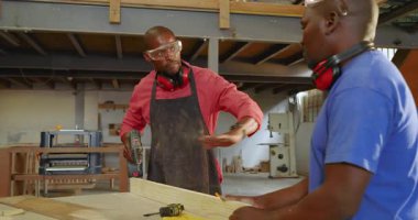 Afrika kökenli Amerikalı iş arkadaşlarının yerleştirilmesi pilot delikleri delmesi atölyede tekniği açıklıyor. El işçiliği, takım çalışması, endüstriyel, kırsal, becerikli, pratik, inşaat