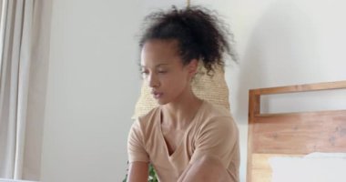 Yatakta dizüstü bilgisayar kullanan, gülümseyen ve evde çalışan bir kadın. Uzaktan çalışma, teknoloji, ev ofisi, yaşam tarzı, mutluluk, eğlence