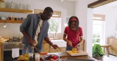 Birlikte yemek hazırlamak, evdeki rahat mutfakta gülen farklı çiftler. Yemek pişirme, takım çalışması, ilişki, aşçılık, eğlence, mutluluk