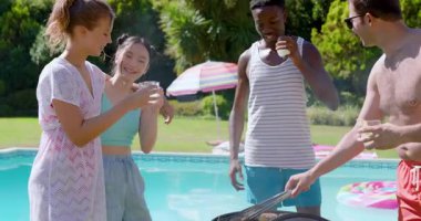 Çeşitli arkadaşlar bilardo barbeküsü için kömür ızgarasında hamburger ve mısır kızartıyorlar. Açık hava, boş zaman, yaz, sosyalleşme, yaşam tarzı, hareketli, gündelik