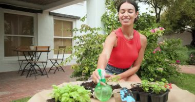 Kadın bahçeyle uğraşıyor, arka bahçeye fidanlar ekiyor, güneşli bir günün tadını çıkarıyor. Güneş ışığı, hobi, peyzaj, doğa, eğlence