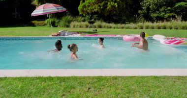 Eğlence için çimlerden koşan arkadaşlar, arka bahçedeki havuza sıçrayan pembe çörek ve top pas veren arkadaşlar. Açık hava, boş zaman, neşeli, canlı, yaşam tarzı, kutlama, tatil