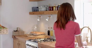 Adam domates tutuyor, mutfakta partnerle yemek pişirirken gülümsüyor. Ortaklık, aşçılık, yerli, mutluluk, yaşam tarzı, ev