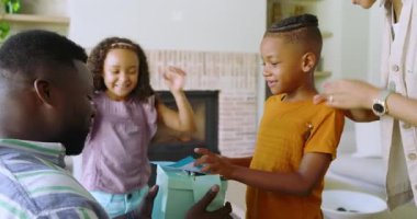 Evde çeşitli aileler toplanıyor, çocuklar hediye kutusu dağıtıyor ve baba el yapımı kart okuyor. Aile, kutlama, hediye, sıcaklık, birliktelik, içtenlik, samimiyet.