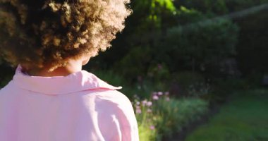 Çiçek tarlasında başını kameraya çeviren, gülümseyen güneşe tepki veren Afrikalı Amerikalı kadın. Doğal, boş, pozitiflik, zarafet, dinginlik, canlılık, yaşam tarzı