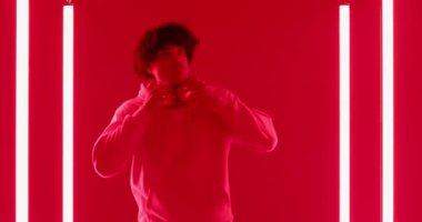 Adam beyaz LED ışık tüpleri ve müzik dinlemek için kulaklık takıyor. Modern, kentsel, neon, gençlik, gündelik, sürükleyici, ortam