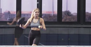 Padel kortuna giren top sektiren adam ve ısınan raketlerle top süren kadın. Sporcu, antrenman, spor, spor, rekabetçi, çeviklik, modern