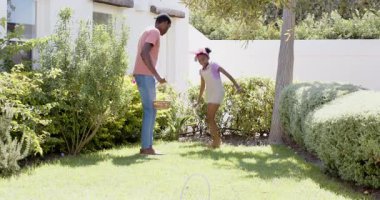 Paskalya, Afrika kökenli Amerikalı baba ve kız güneşli arka bahçede yakalamaca oynuyorlar, tatil. Çeşit çeşit aile, bağ, bahçe, eğlence, eğlence, çim