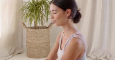 Evde yoga yapan genç bir kadın elleri dua pozisyonunda meditasyon yapıyor. Meditasyon, sağlık, sükunet, rahatlama, farkındalık, egzersiz