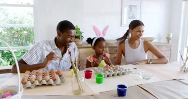 Çeşitli aileler Paskalya yumurtalarını boyuyor, yaratıcı zamanlarını evde mutlu bir şekilde paylaşıyorlar. yaratıcılık, bağlanma, tatil, kutlama, gelenek, çeşitlilik