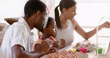 Paskalya, çeşitli aileler mutfak masasında yumurta boyuyor, bahçede yaratıcı tatil aktivitelerinin tadını çıkarıyor. yaratıcılık, Paskalya, bağ, kutlama, gelenek, el sanatları