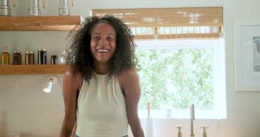 Mutfakta gülümseyen kadın sabah rutininin keyfini çıkarıyor, evde doğal ışıkla çevrili. Yaşam tarzı, aile hayatı, mutluluk, ev, sükunet, kahvaltı