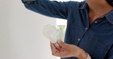 Modern lambada ampulü değiştirmek, enerji verimliliğine odaklanmak. Işıklandırma, enerji tasarrufu, çevre dostu, sürdürülebilir, ev geliştirme, iç mekan