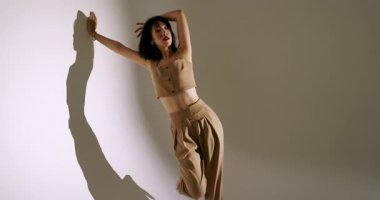 Uzamış gölgeye dikkat çeken Asyalı bayan dansçı beyaz duvardaki spot ışıklarıyla ana hatlarını çiziyor. Sanatsal, siluet, hareket, minimalizm, performans, yaratıcı, koreografi