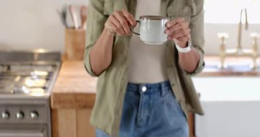 Evde kahve içen bir kadın, düşünceli bir ifadeyle pencereden dışarı bakıyor. Rahatlama, tefekkür, sabah, konfor, konfor, yalnızlık