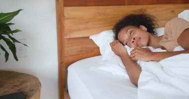 Yatakta dinlenen, gülümseyen ve sabah evde eğlenen bir kadın. Rahat, rahat, yaşam tarzı, konfor, mutluluk, rahatlama