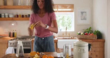 Smiling woman in kitchen peeling banana for healthy breakfast preparation, at home. Healthy eating, nutrition, morning routine, wellness, fruit, culinary