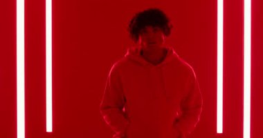 Kırmızı ışıklı kapüşonlu stüdyoya girdikten sonra taburede oturup LED tüplerini kontrol etti. Minimalist, yaratıcı, çağdaş, ifade, ambians, teknoloji, sanatsal