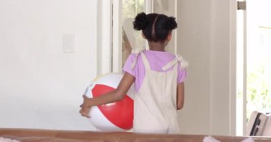 Çeşitli aileler tatil evlerine geliyorlar, gülümsüyorlar ve bavullarını ve plaj toplarını taşıyorlar. Seyahat, varış, tatil, tatil