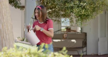 Bahçede sulayan bitkiler, bahçede birlikte çalışan farklı çiftler. Bahçıvanlık, bahçıvanlık, takım çalışması, doğa, işbirliği, ekme