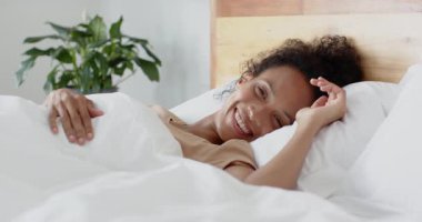 Bir kadın yatakta uyanıyor, gülümsüyor ve esniyor, sabah rahatlığının tadını çıkarıyor, evde. Uyanın, mutluluk, yaşam tarzı, yatak odası, gün doğumu