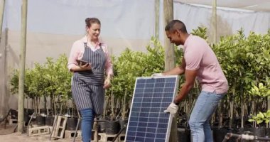 Bitki yetiştirme, bahçecilik, çeşitli takımlar güneş paneli kurulumunu tartışıyor, serada. sürdürülebilirlik, yenilenebilirlik, takım çalışması, işbirliği, çevre dostu, bahçecilik