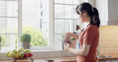 Güneş ışığı, Asyalı bir kadının mutfak tezgahında Fransız presi yapmasını kahve yudumlamasını, telefonları kaydırmasını teşvik ediyor. Günaydın, içecek, rahat, yaşam tarzı, kentsel, doğal, rahatla