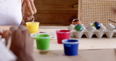 Paskalya, gülümseyen kadın evde renkli yumurta boyuyor, yaratıcı aktivitelerden zevk alıyor. Paskalya, yaratıcılık, hobi, dekorasyon, festival, gelenek