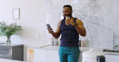 Afrika kökenli Amerikalı bir adam kapalı alanda duruyor, akıllı telefonu mermer duvarla karşılaştırıyor. Akıllı telefon, modern, teknoloji, konsantrasyon, çağdaş, estetik, gelişigüzel