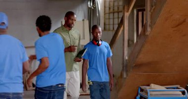 Afro-Amerikan ustabaşı tableti inceliyor sonra da atölye açısında çerçeve eklemini inceliyor. İşçilik, akıl hocalığı, meslek, sanayi, kılavuz, eğitim, işbirliği