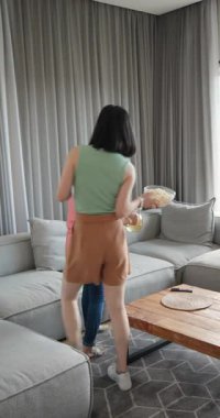 Dikey video: Anne ve kızı sıcak oturma odasındaki kanepede patlamış mısırın tadını çıkarıyorlar. Aile, yakınlaşma, rahatlama, rahatlama, atıştırma, eğlence.