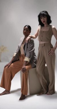 Dikey video: Modern moda stüdyosunda kendine güvenen şık kıyafetler giyen iki kadın. stil, zarafet, güven, trend, çağdaş, moda