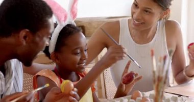 Çeşitli aileler Paskalya yumurtalarını birlikte boyuyor, gülümsüyor ve evde yaratıcı zaman geçiriyorlar. yaratıcılık, gelenek, kutlama, bağ, beceri, festival