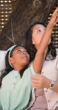 Dikey video: Anne ve kızı dışarıda birlikte gülüyor, kaliteli vakit geçirmenin keyfini çıkarıyorlar. Aile, mutluluk, bağlantı, aşk, ebeveynlik, birliktelik.