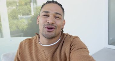 Yirmili yaşlarda erkek, balkonda ağzı açık, parmaklıklı, kameralı ve el kol hareketleriyle konuşuyor. Vlog, açık hava, açık hava, rahat yaşam tarzı, gündelik, hikaye anlatımı