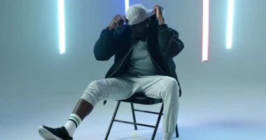 Afrikalı Amerikalı bir adam basketbolu yaya olarak fark ediyor, atölyedeki bombardıman ceketinin salyalarını akıtıyor ve ayarlıyor. Atletik, gündelik, spor, hareket, kentsel, enerjik, modern