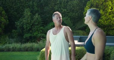 Havuzda dinlenen olgun bir çift sabah sükuneti ve beraberliği kucaklıyor. Tatil, tatil, rahatlama, çiftler, aşk, uyum.