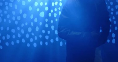 Sahne ışıkları altında Afrika kökenli Amerikalı bir adam, güneş gözlüklerini kol saati üzerinden ceketinden çıkartıyor. Gizemli, sinematik, fütüristik, şık, dramatik, kentsel, gece hayatı