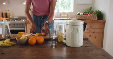 Mutfakta taze meyve püresi hazırlamak, evde portakal ve muz dilimleyen bir kadın. Sağlıklı, beslenme, içecek, yemek, vegan, malzemeler