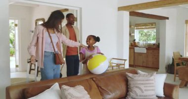 Çeşitli aileler tatil evlerine geliyor, gülümsüyorlar ve plaj topu tutuyorlar. seyahat, yaz, tatil, eğlence, kaçamak