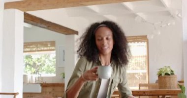 Evde dinlenen, kanepede kahve içen düşünceli ve mutlu bir kadın. Rahatlama, rahatlama, tefekkür, rahatlık, sıcaklık.