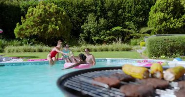 Izgara dumanı tütüyor, çeşitli arkadaşlar şişe uzatıyor, bardakları tokuşturuyor, yudumluyor ve havuz başında gülüyor. Yaz, tatil, açık hava, gündelik, kutlama, coşku, arkadaşlık.