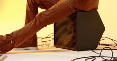 Saate bakan, stüdyoda oturan, tasmasını ayarlayan, ayna çerçevesiyle güneş gözlüğü tutan siyah bir adam. Moda, güven, tarz, zarafet, modernlik, portre, yaratıcılık