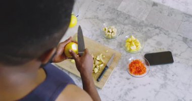 Afro-Amerikalı adam mutfaktaki mermer tezgahta ananas dilimliyor, kaselere meyve koyuyor. Meyve, hazırlık, yemek pişirme, mutfak, sağlıklı, aşçılık, modern
