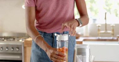 Mutfakta taze meyve püresi hazırlıyorum, kadın malzemeleri odak noktasıyla karıştırıyor, evde. Sağlıklı beslenme, yaşam tarzı, yemek pişirme, sağlık, aşçılık.