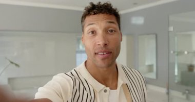 Adam tuvalette karşılıyor, akıllı telefon lenslerini dinliyor odak noktasını ayarlıyor, duşu ve bitkiyi gösteriyor. Teknoloji, yaşam tarzı, modern, iç mekan, günlük, otantik, sağlık