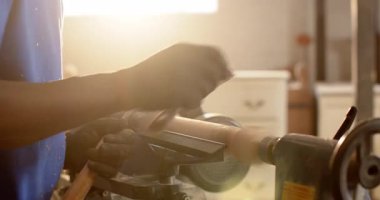 Eldivenli Afro-Amerikalı adam, alet istirahatını ayarlıyor, torna torbasını etkinleştiriyor, atölyede şekil veriyor. Sanatçı, marangozluk, işçilik, iç mimarlık, zanaatçılık, yaratıcılık, tasarım
