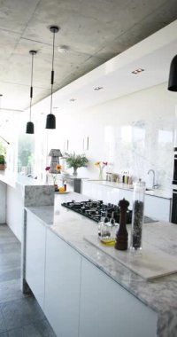 Dikey video: Parlak, ferah modern mutfak tasarımı mermer tezgah ve parlak aletler. Çağdaş, iç mekan, lüks, ev, yaşam tarzı, zarif