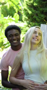 Dikey video: Genç çift açık havada kucaklaşıyor, gülümsüyor ve havuz başında güneşli bir günün tadını çıkarıyor. Mutluluk, şefkat, havuz başı, neşe, tatil, yaz mevsimi